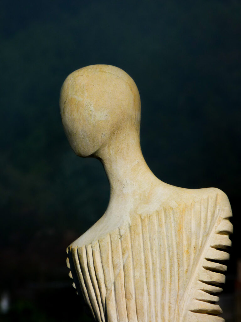 Escultura de un busto tallado en madera sin rasgos faciales