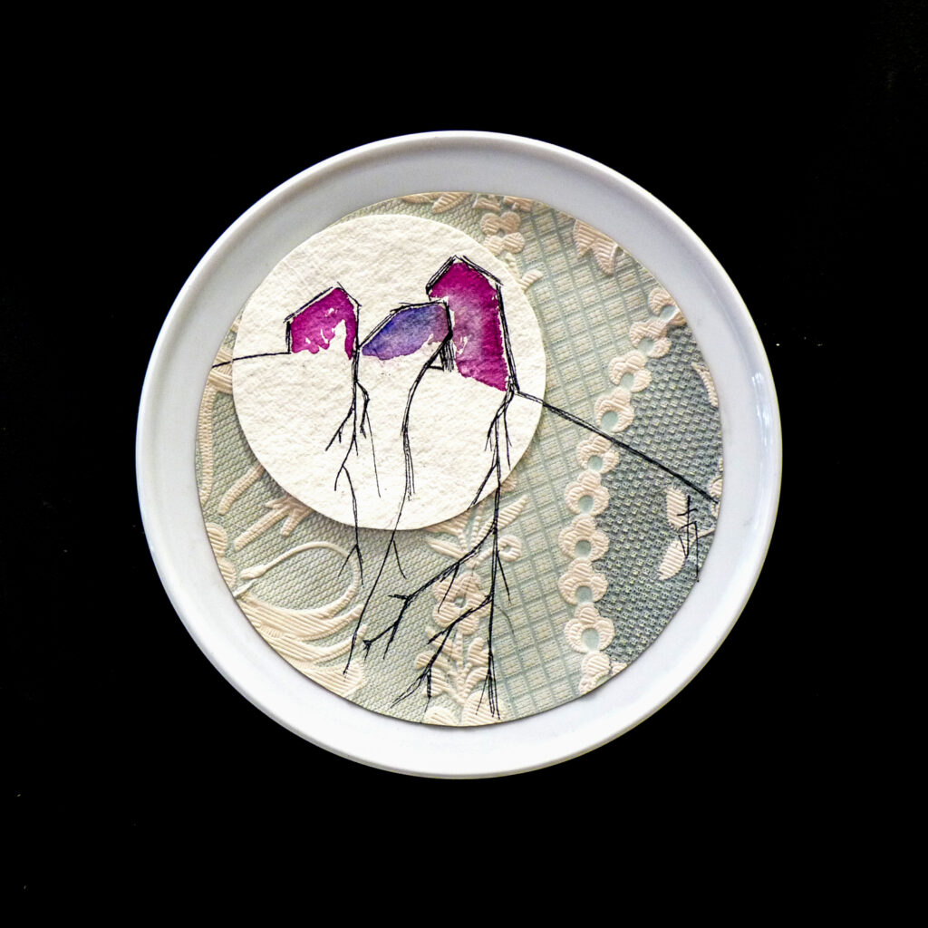 plato blanco decorado con patrones en color gris y flores rosas y moradas